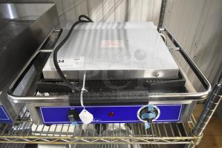Brand new Globe GPG1410 stainless steel commercial panini press, 120 volts, 1 phase, with control dial and tags displayed.