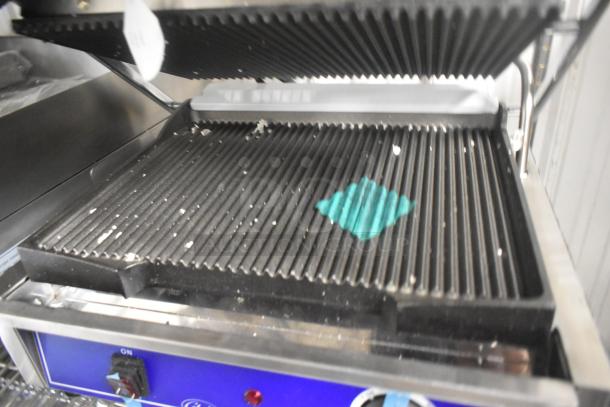 Brand new Globe GPG1410 stainless steel commercial panini press, 120V, 1 phase, ribbed grill plates, blue control panel.