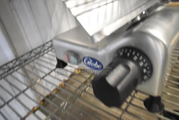 BRAND NEW Globe G10 stainless steel meat slicer with blade sharpener. Features 120V, 1 phase power, countertop design.
