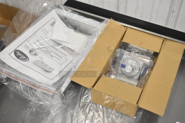 Brand new Globe GG48TG stainless steel commercial griddle parts, packaging, and manual visible, ready for assembly.