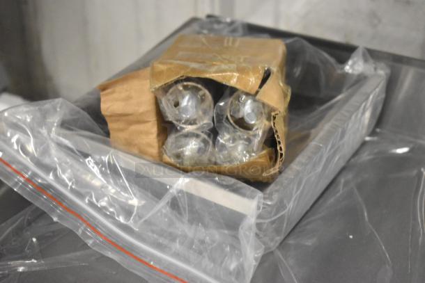 Cardboard box with wrapped stainless steel components for a Globe PG24E griddle, showing protective packaging.