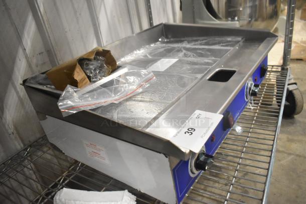 Brand new 2024 Globe PG24E stainless steel flat top griddle, electric, 208/240V, 1 Phase, on a metal shelf, with control knobs.