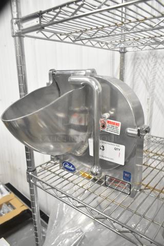 Brand new Globe metal commercial pelican head with slicing blade, warning label visible, stainless steel finish.