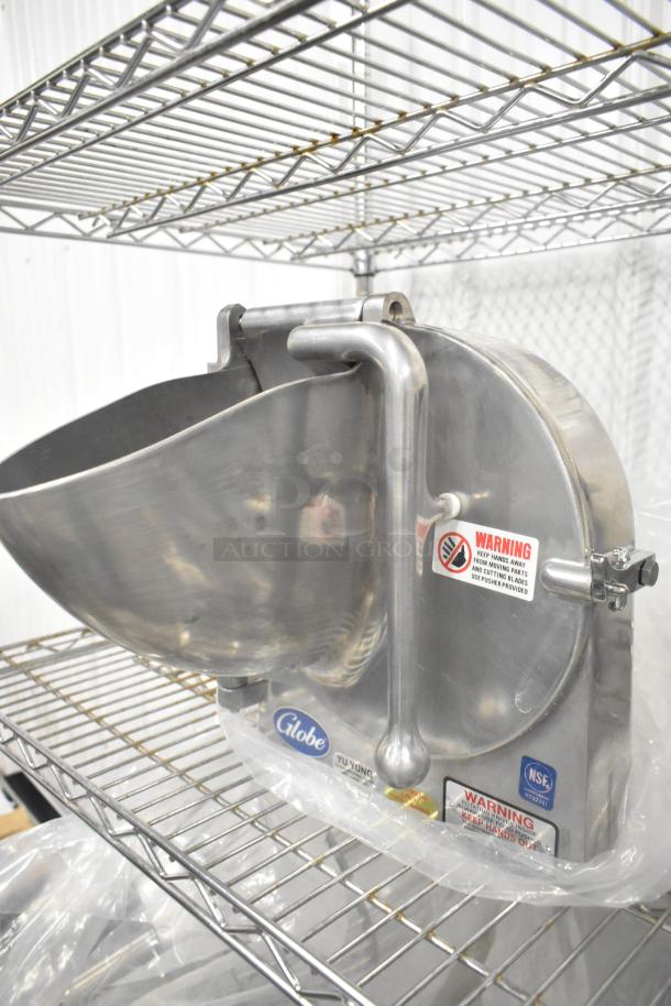 Brand new Globe metal commercial pelican head, no blade, with warning labels and Globe branding visible, on metal shelving.