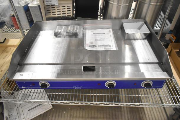 Brand new Globe GEG36 electric griddle, stainless steel, 208/240 volts, with controls and documentation on a countertop.