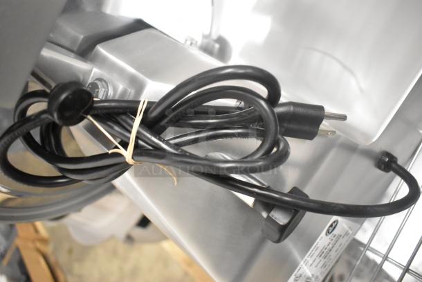 Brand new Globe C12 stainless steel meat slicer with blade sharpener, 115 volts, 1 phase, includes attached power cord.