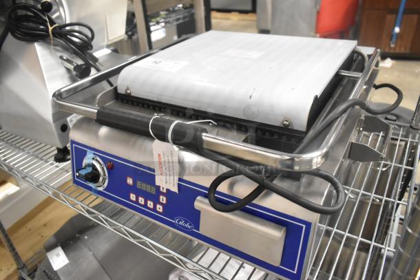 Brand new Globe GPG14D stainless steel commercial panini press, 120V, 1 phase, digital controls, on shelf.