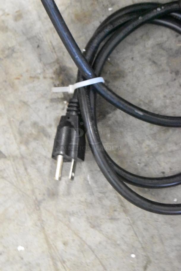 Brand new Globe GVP20 vacuum sealer's power cord with plug, coiled on a concrete floor.