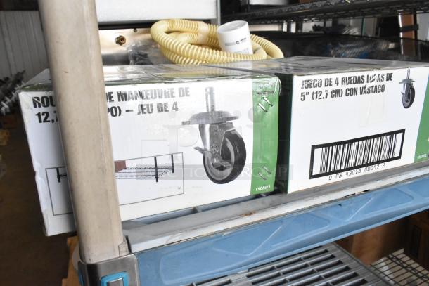 Two boxes of Focus commercial casters, each containing four 5" wheels, brand new with packaging.