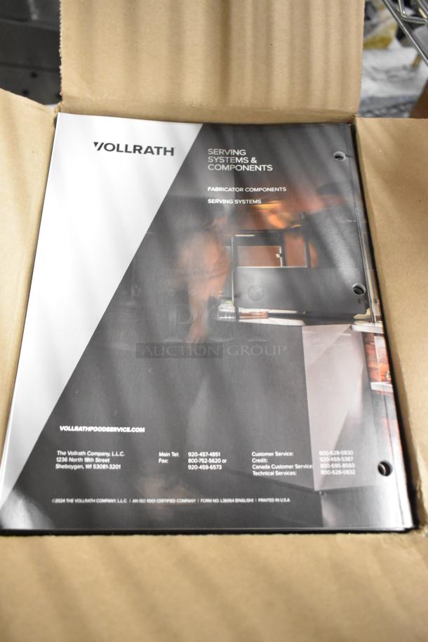 Three brand new boxes of Vollrath booklets on serving systems, featuring company details and component information.