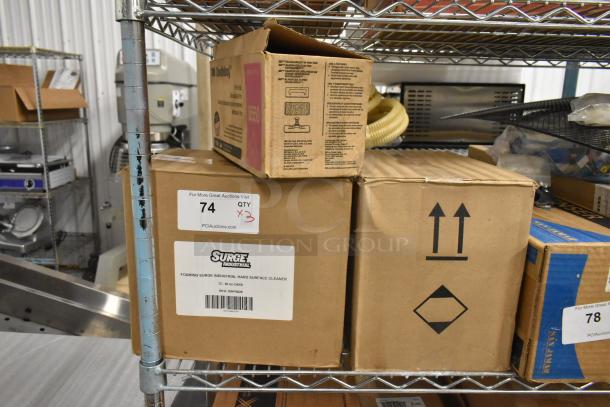 Three boxes on a shelf, including 3M Doodlebug Hi Pro Pads and Foaming Surge Industrial Surface Cleaner. Auction label shows quantity 3.