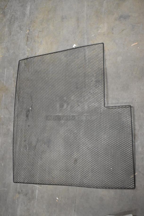 Alt text: Black mesh rack piece on concrete floor, part of a mixed items lot.