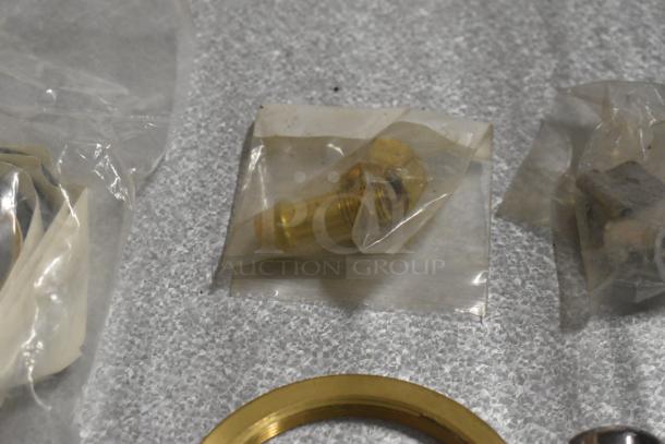 Various small metal parts, including handles and racks, in clear plastic packaging. Items appear in good condition.