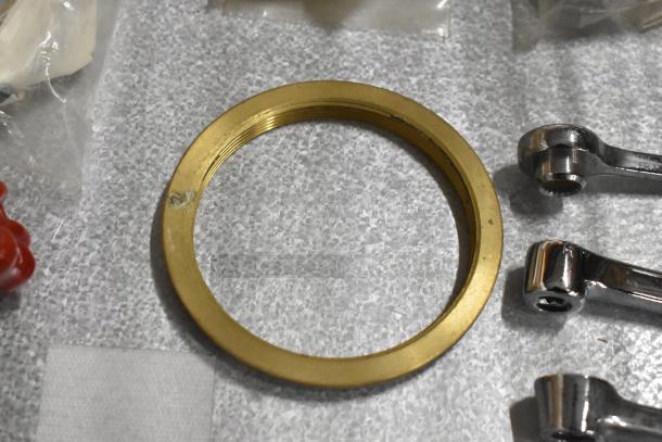 Lot of various items including a brass ring and chrome handles on a textured surface, suitable for restoration projects.