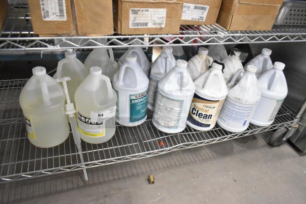 20 jugs of cleaners, including Broad-cide 128 and Neutral Clean Floor Cleanser, placed on a metal shelf.