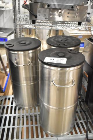 Bloomfield 8799 stainless steel iced tea dispensers, brand new, set of three, with black lids and handles. Auction tag visible.