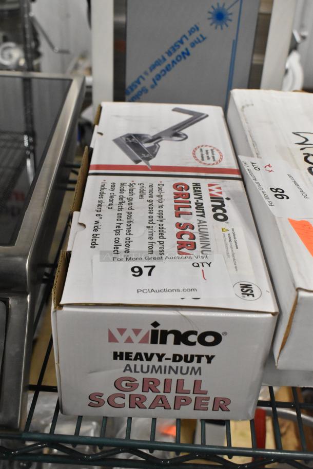 Brand new Winco Heavy Duty Aluminum Grill Scraper in box, featuring dual-grip handle and sharp 6" wide blade.