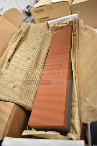 New red bricks in packaging, showing a smooth finish. Unused condition, packed in cardboard and protective wrapping.