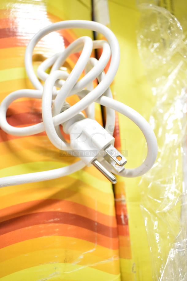 Coiled white power cord on colorful striped background, part of a ChocoVision C116USREV2WHI chocolate tempering machine.