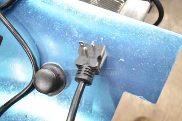 Alt text: Close-up of power cord for Avantco F202 electric countertop fryer, showing a three-prong plug on a blue surface.