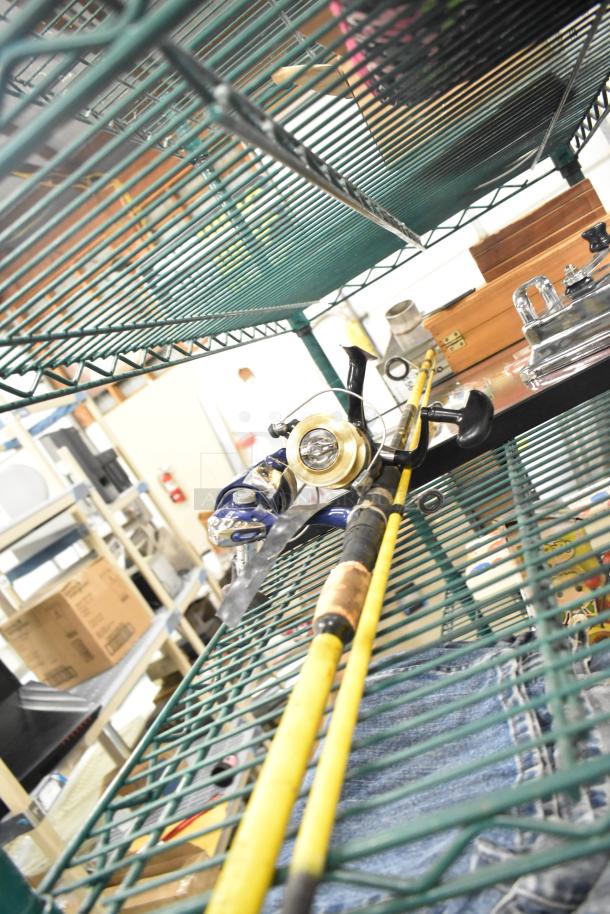 Fishing rod on metal shelf, with a wooden box and other assorted items. Condition appears used.