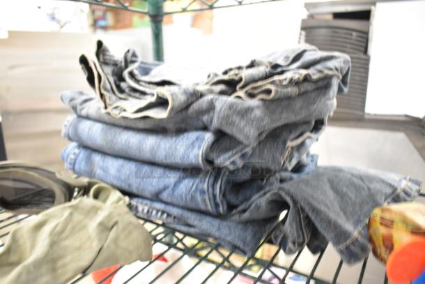 Folded jeans on a shelf alongside a Pez dispenser and other items, auction lot including HP1195748 igniter and flame sensor.