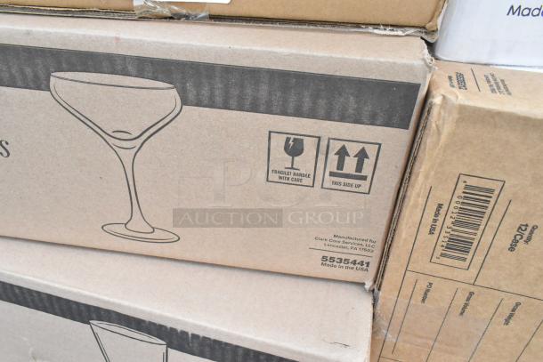 Cardboard boxes labeled "Fragile" with cocktail glass icon, indicating the contents include new glasses and plastic tumblers.