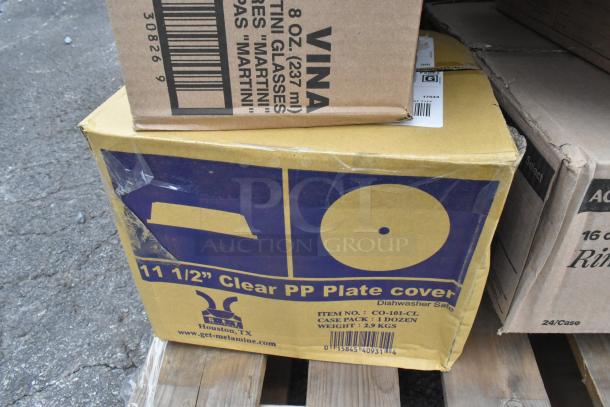 Cardboard boxes containing scratch and dent 8 oz martini glasses and 11.5" clear PP plate covers. Some packaging wear visible.