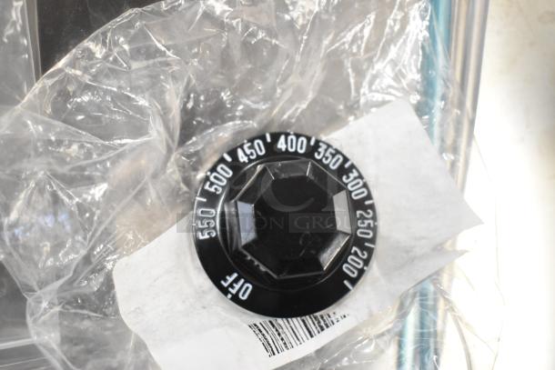 Black thermostatic control knob with temperature markings from 200 to 550 degrees, new in packaging.