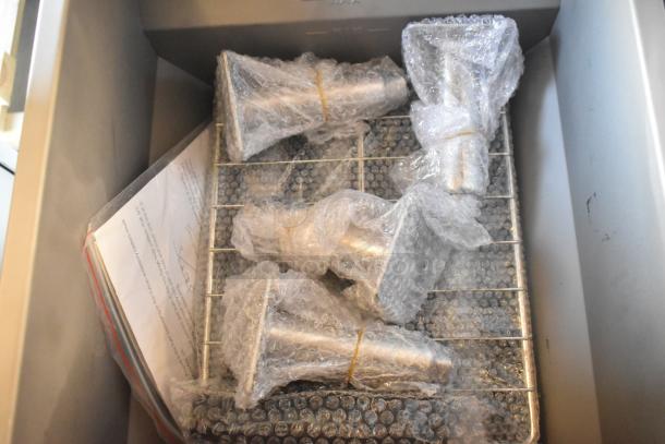 Stainless steel components of Vulcan LG300-2 fryer in bubble wrap inside a metal basket, indicating new condition.