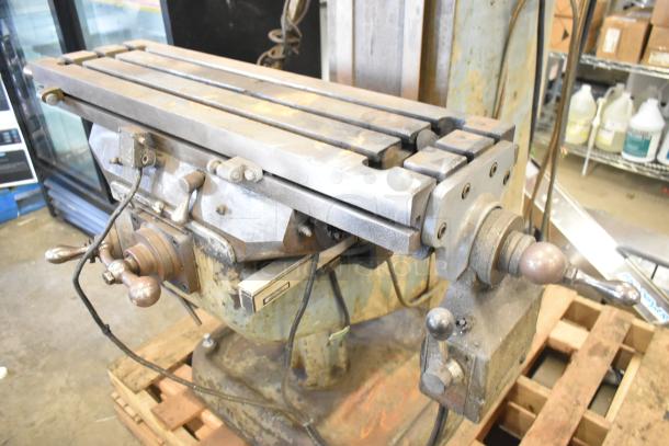 Bridgeport metal milling machine with worn finish, crank handles, and Turnvision monitor; industrial-grade and durable.