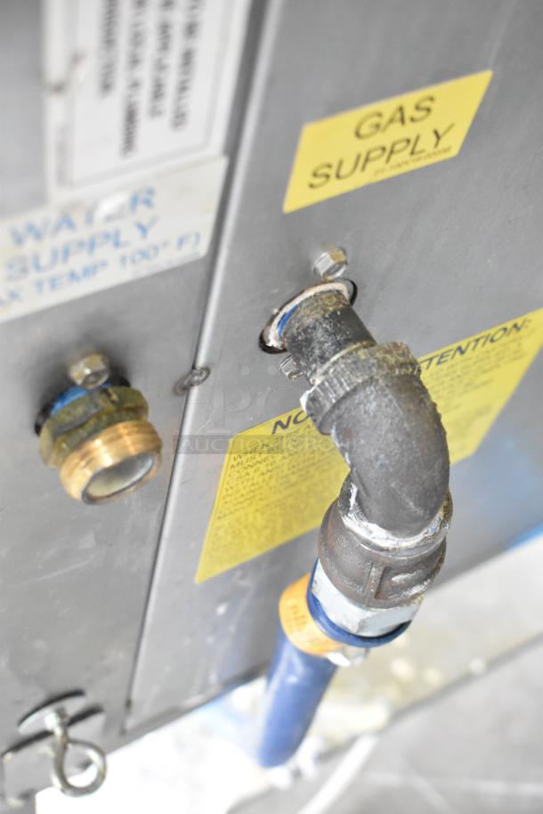 Baxter BV400G stainless steel commercial gas rack oven; gas and water supply fittings visible, indicating connections.