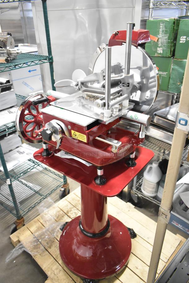 BRAND NEW Globe FS12 metal commercial flywheel meat slicer with blade sharpener, on red pedestal, model FS12, pristine condition.