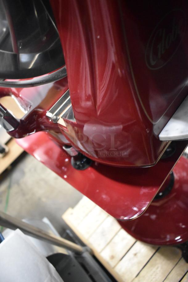 Brand new Globe FS12 metal commercial meat slicer with blade sharpener; glossy red finish, sturdy construction.