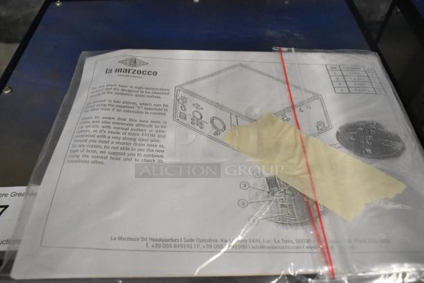 La Marzocco Modbar Espresso AV System manual and parts list visible, detailing installation instructions and specifications.