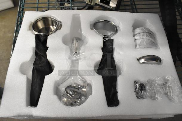Brand new La Marzocco Modbar Espresso AV System components in foam packaging, including metal portafilters and handles.