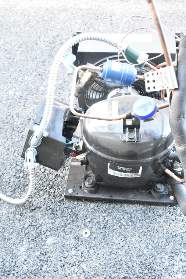 Brand new Copeland M7JP-H021-IAA-072 compressor, 115 volts, 1 phase. Tags indicate oil charge. Auction includes two units.