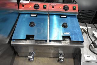 Brand new Avantco F202 dual tank fryer, 30 lb capacity, with 2 metal lids and baskets, 208-240V, minor scratches.
