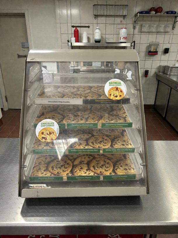 Subway 4-shelf cookie display case, great condition, countertop model. Features labeled trays for various cookie types.