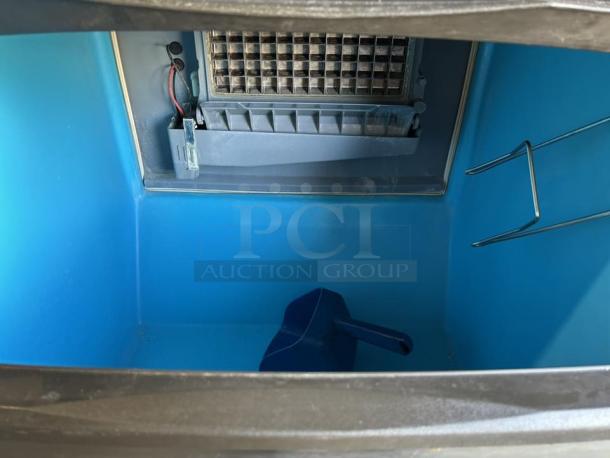 Manitowoc Ice UDF0140A machine interior; clean, blue compartment, ice grid, visible wiring, includes scooper.