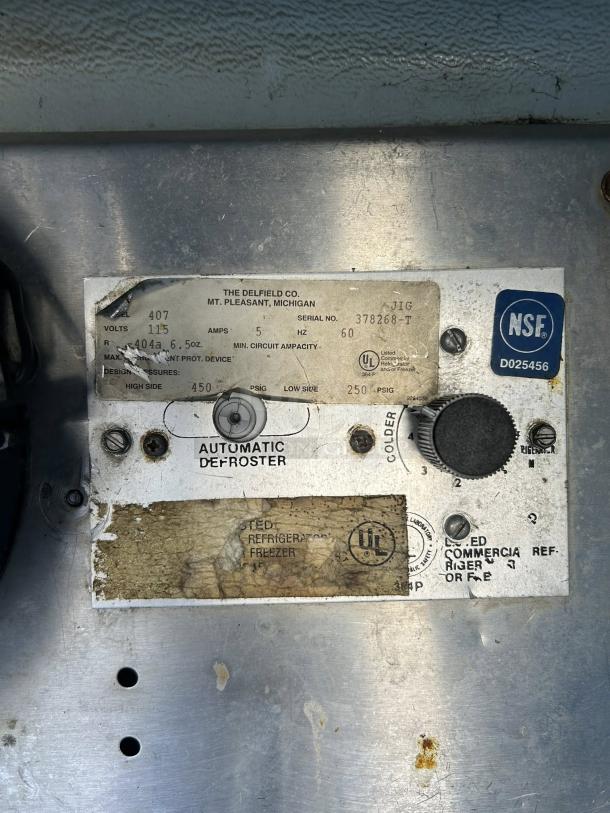 Delfield 407 undercounter refrigerator label showing model, voltage, and specs. Features automatic defroster dial.