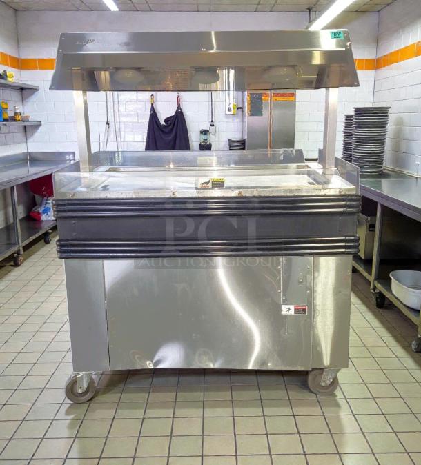 BKI MM-4 heated merchandiser display in stainless steel, tested and working. Features wheels, clear display cover, labels visible.