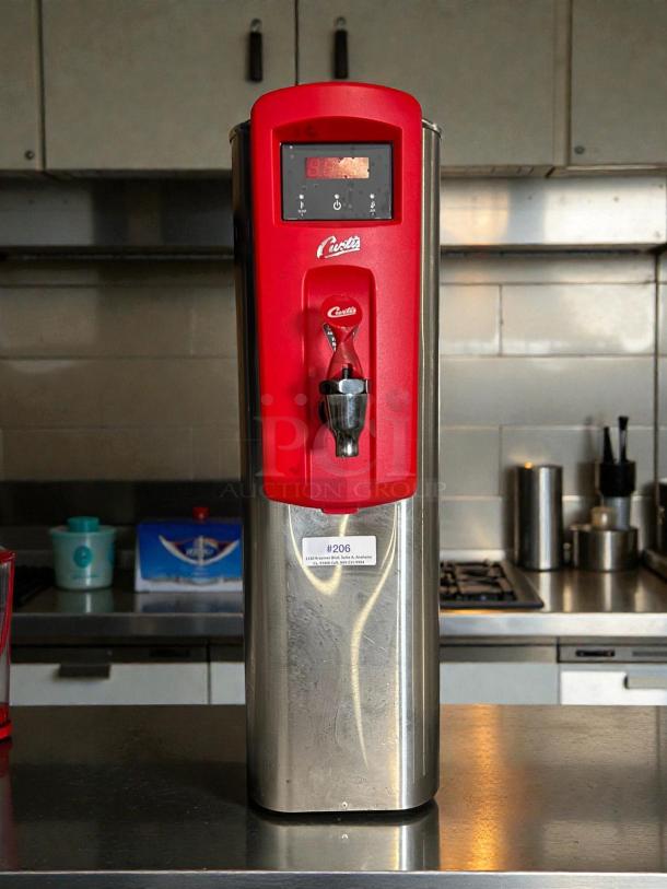 Curtis WB5N hot water dispenser in excellent condition; tested, working, stainless steel with red accents, model shown on kitchen counter.
