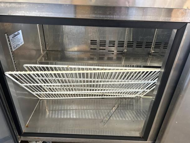 Blue Air BAPT60 two-door sandwich prep table refrigerator in excellent condition, tested and working. Interior shelves shown.