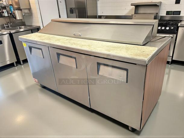 True TSSU-72-18-HC refrigerated sandwich prep table in excellent condition, features three doors and a durable worktop.