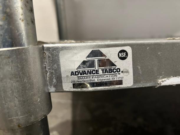 Advance Tabco Model TT-306 stainless steel tag. NSF logo, Edgewood, NY address. Slight wear visible.