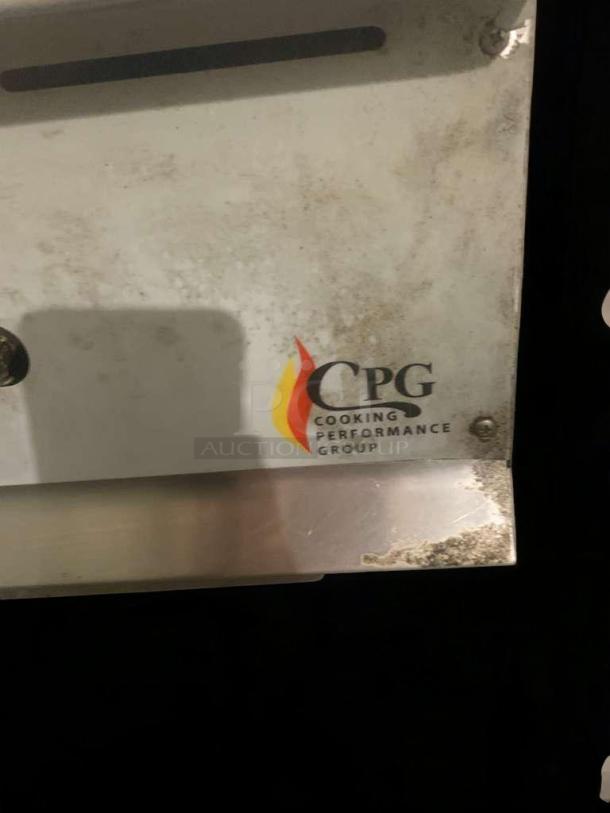Cooking Performance Group logo on a stainless steel appliance panel; close-up shows usage wear.