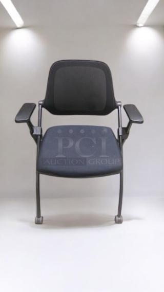 Stackable mesh office chair in premium condition, features armrests and caster wheels. Fully tested and ready for use.