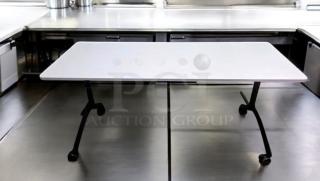 Flip-top training table with locking casters in prime condition, fully functional, on stainless steel surface.