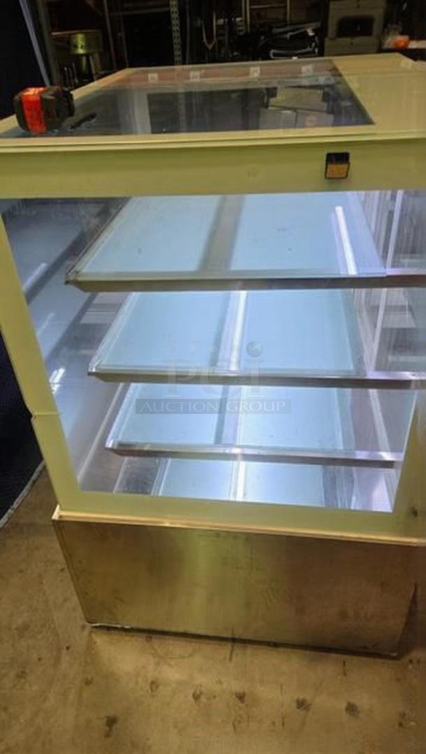 Commercial bakery enclosed display case in remarkable condition, fully tested and working, features multiple glass shelves.